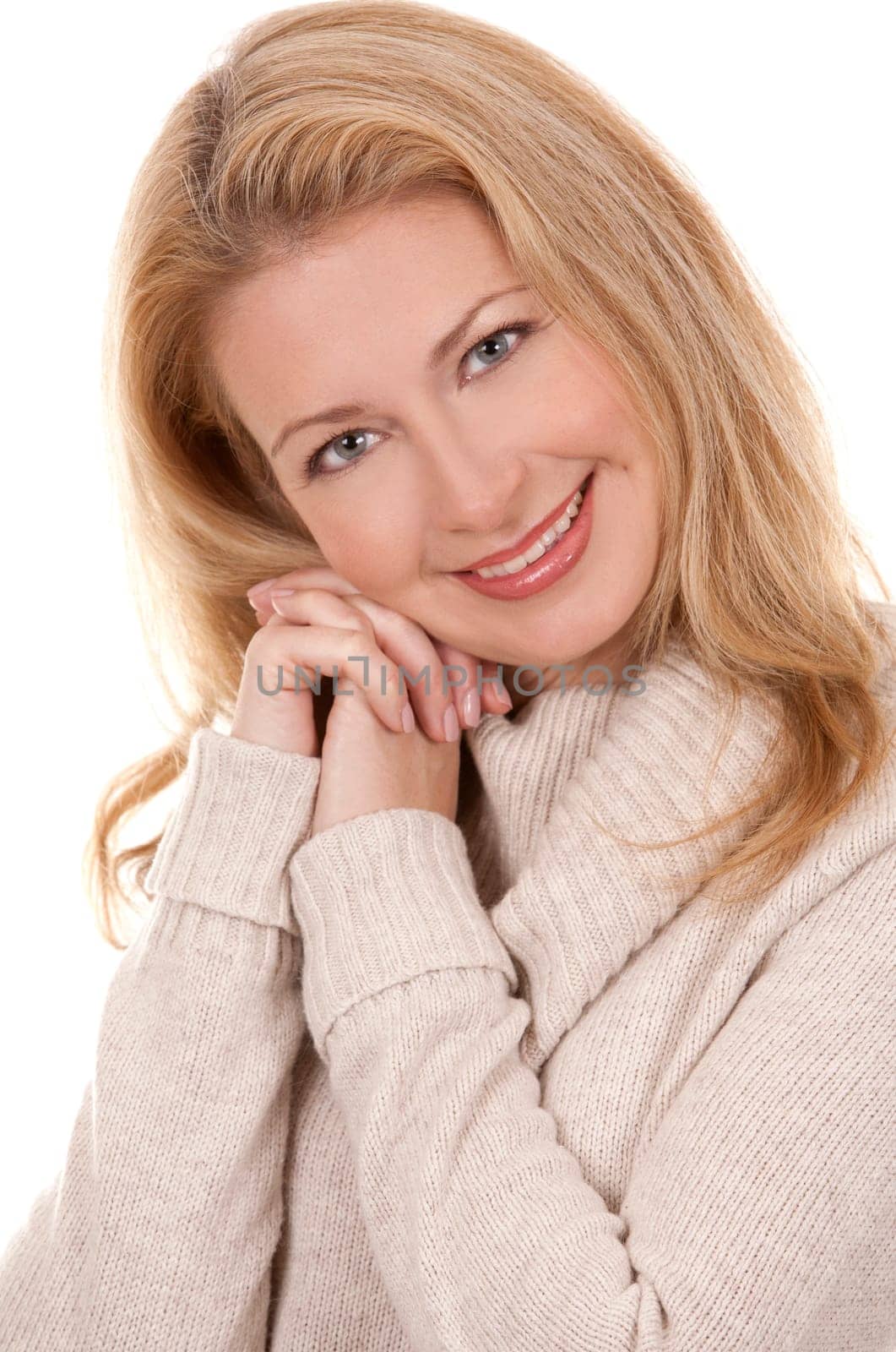 pretty blond woman wearing beige top sitting on white background