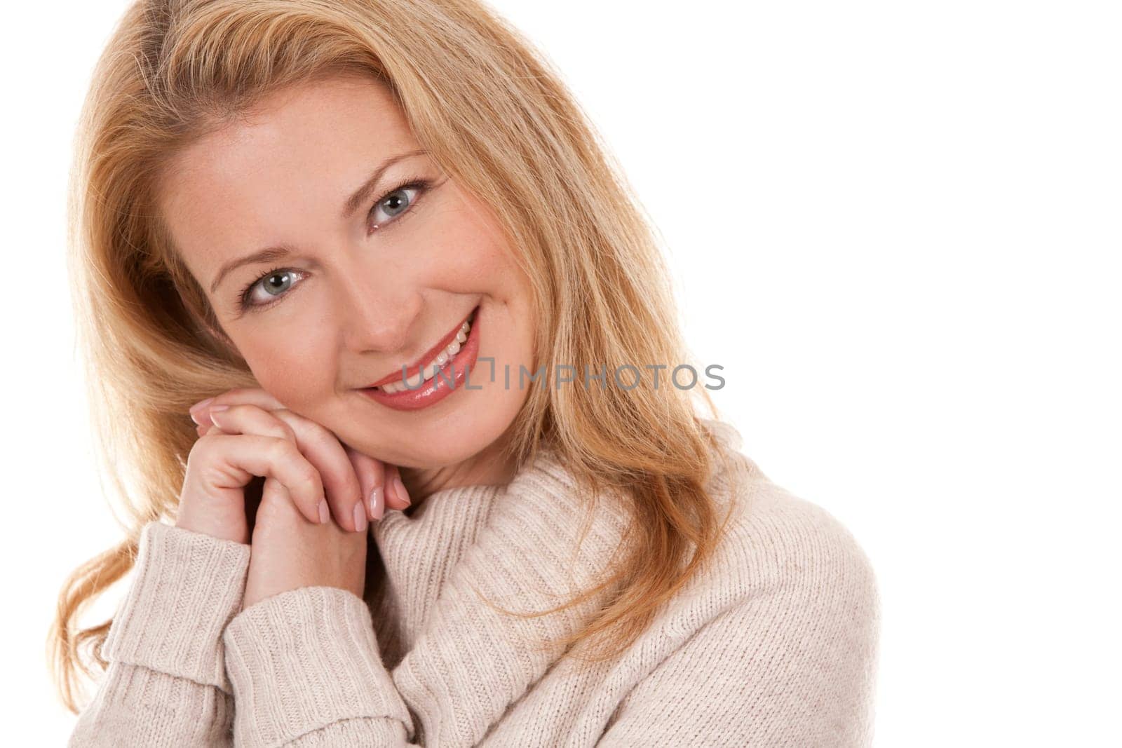 pretty blond woman wearing beige top sitting on white background