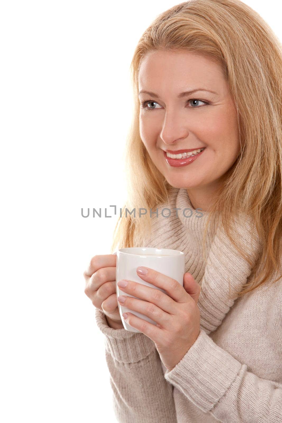 pretty blond woman wearing beige sweather drinking coffee