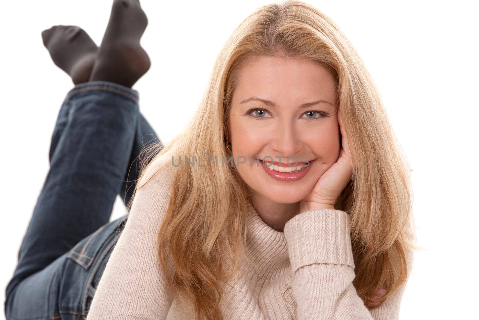 pretty blond woman wearing beige top sitting on white background