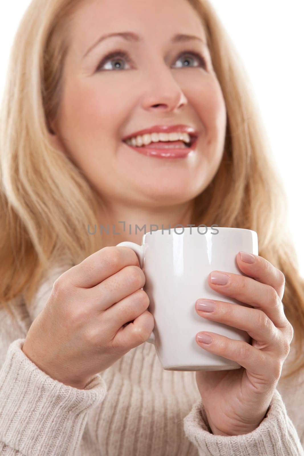 pretty blond woman wearing beige sweather drinking coffee