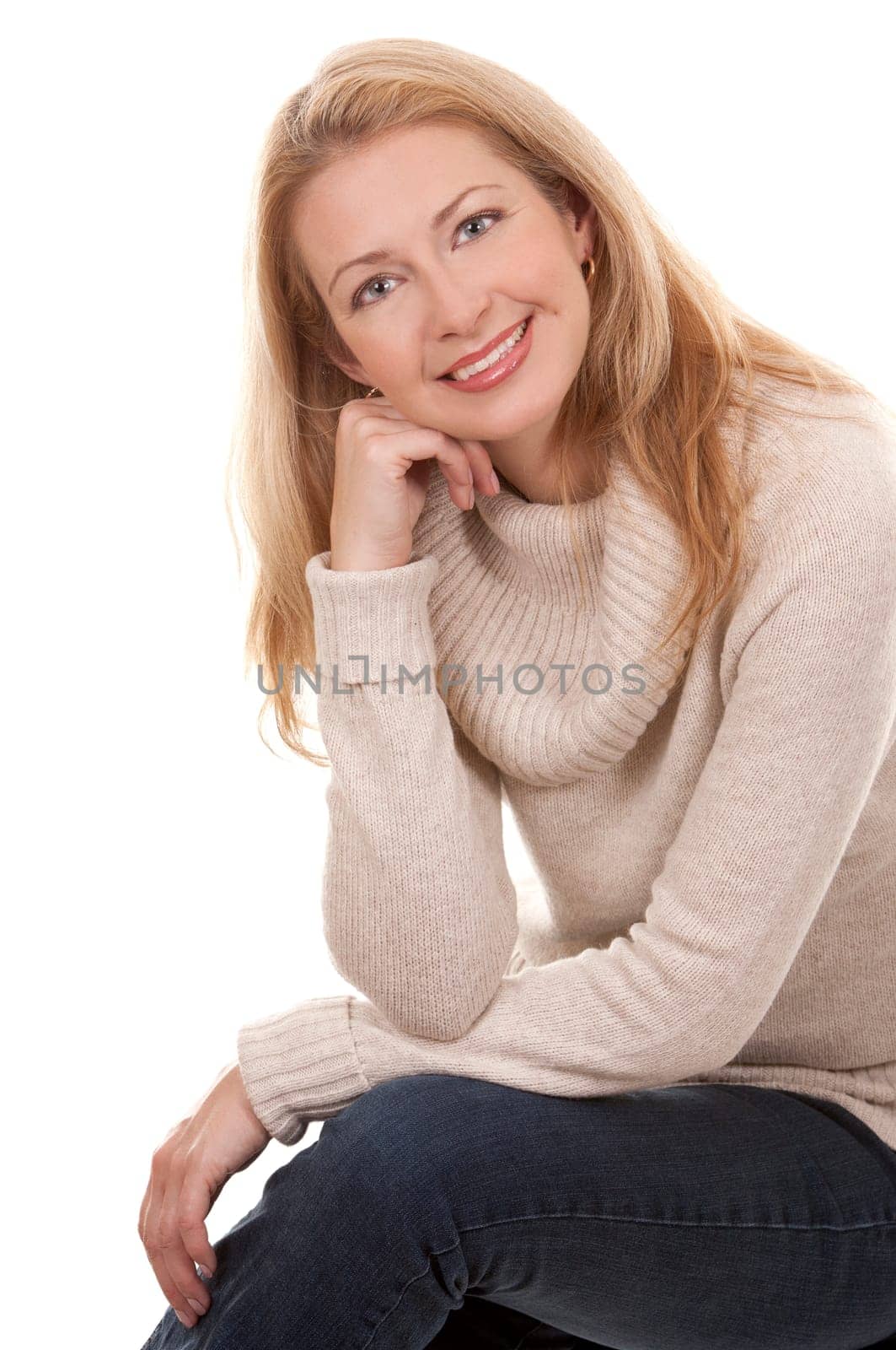 pretty blond woman wearing beige top sitting on white background