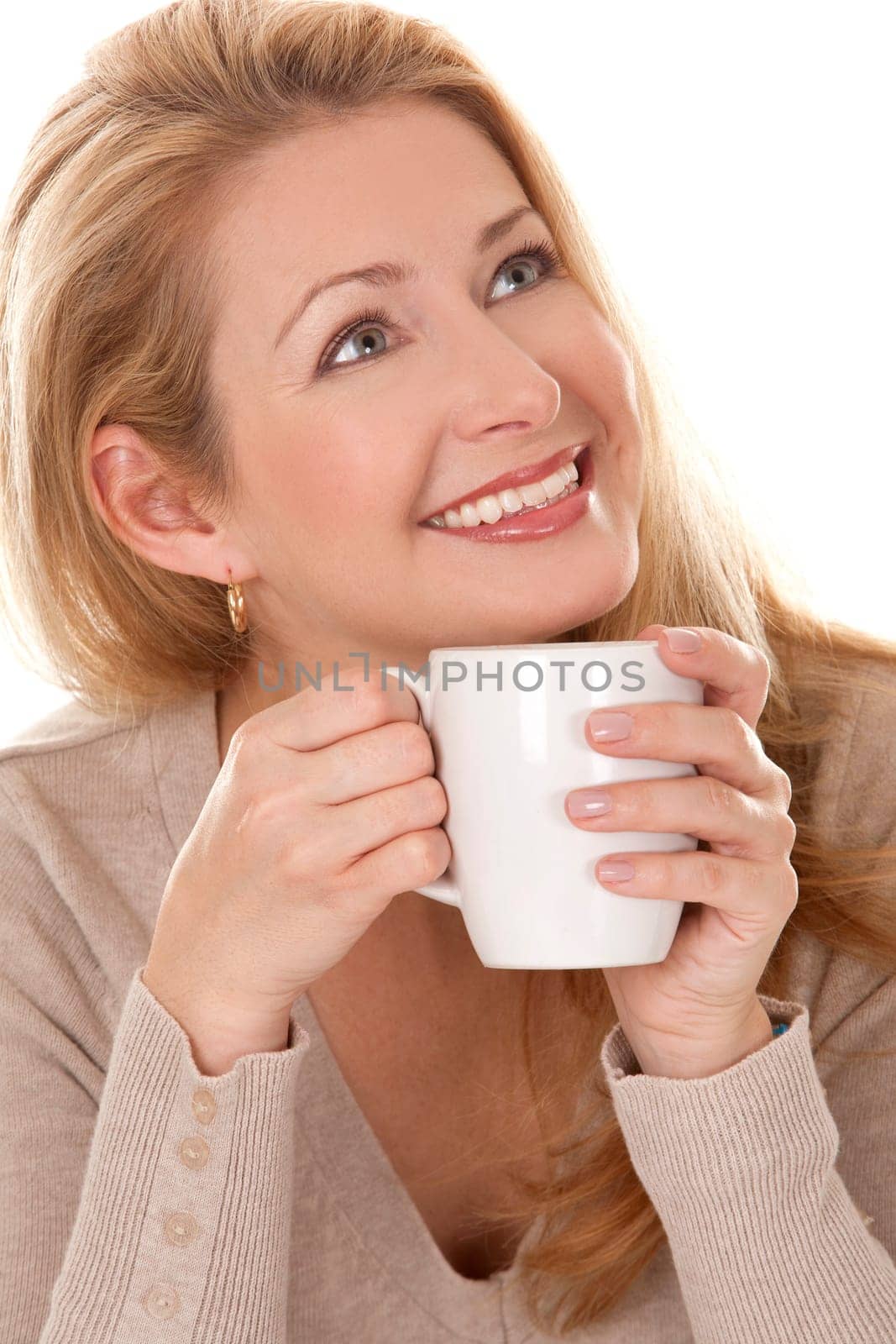 pretty blond woman wearing beige sweather drinking coffee