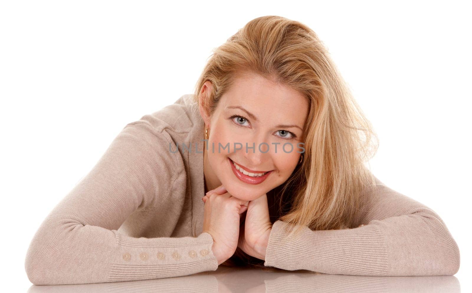 pretty blond woman wearing beige top sitting on white background