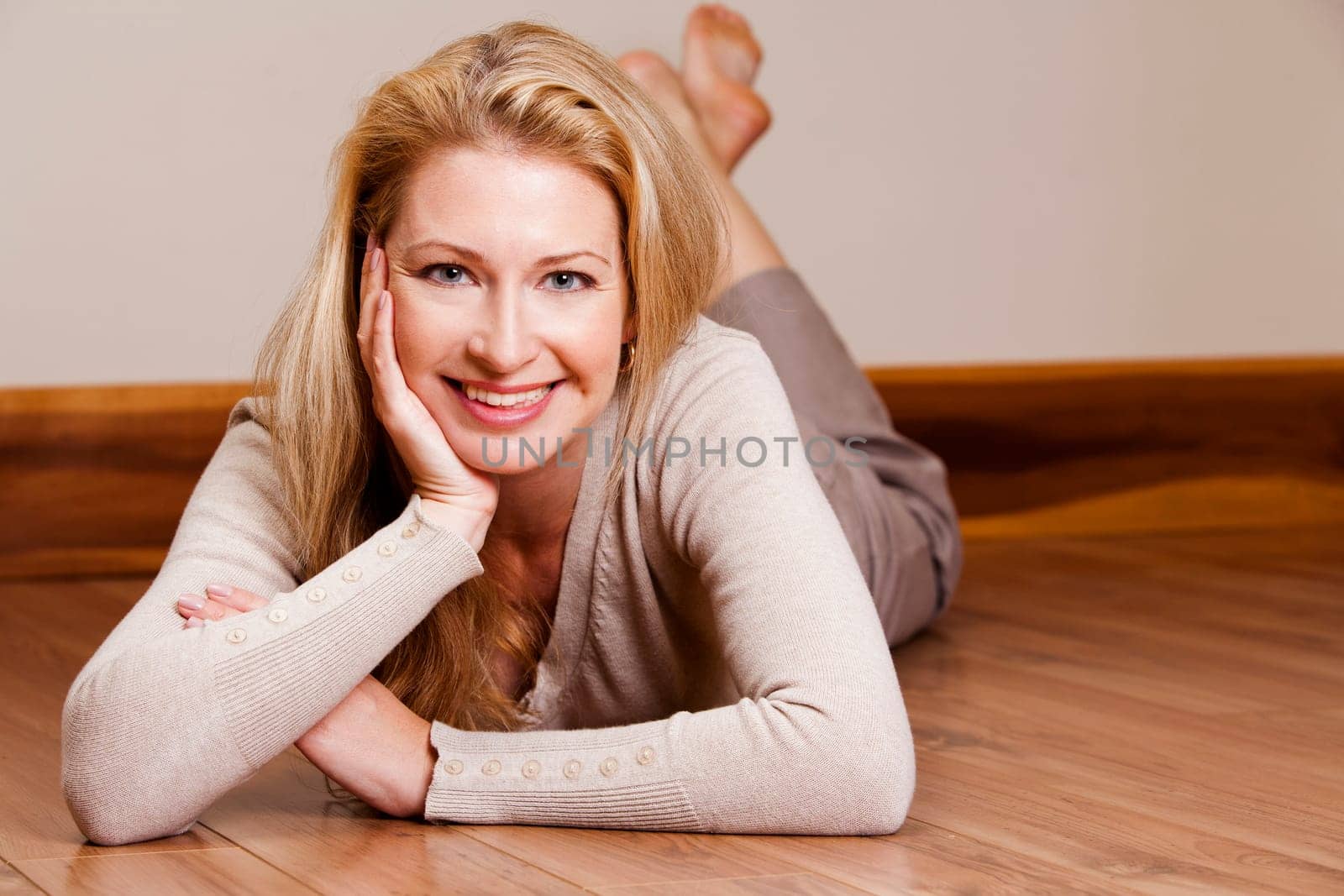 pretty blond woman wearing beige top relaxing on the floor