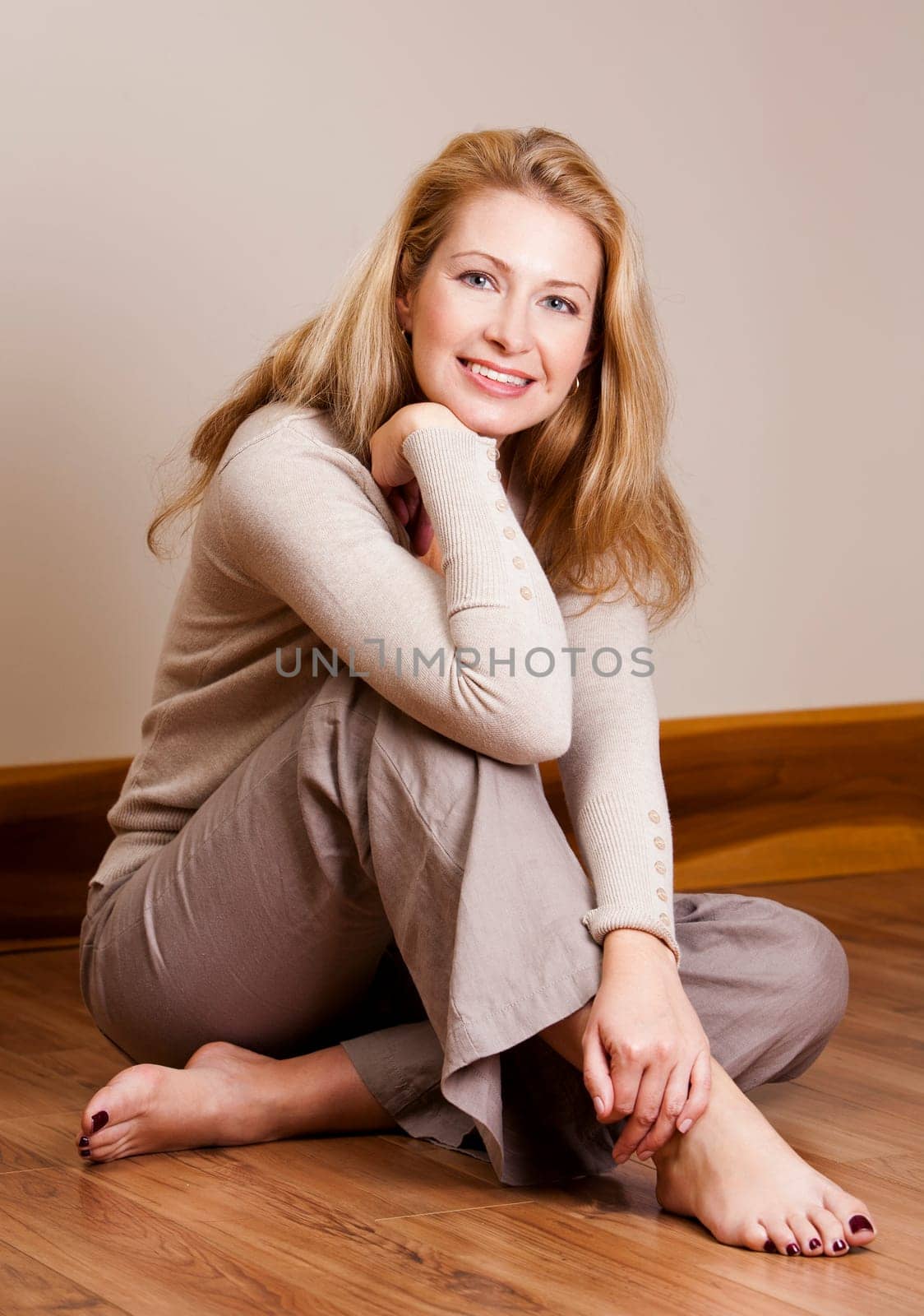 pretty blond woman wearing beige top relaxing on the floor