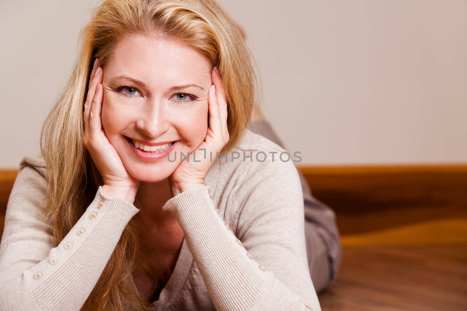 pretty blond woman wearing beige top relaxing on the floor