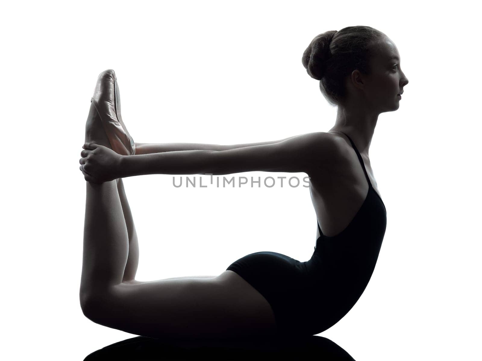 one caucasian young woman ballerina ballet dancer stretching warming up in silhouette studio on white background