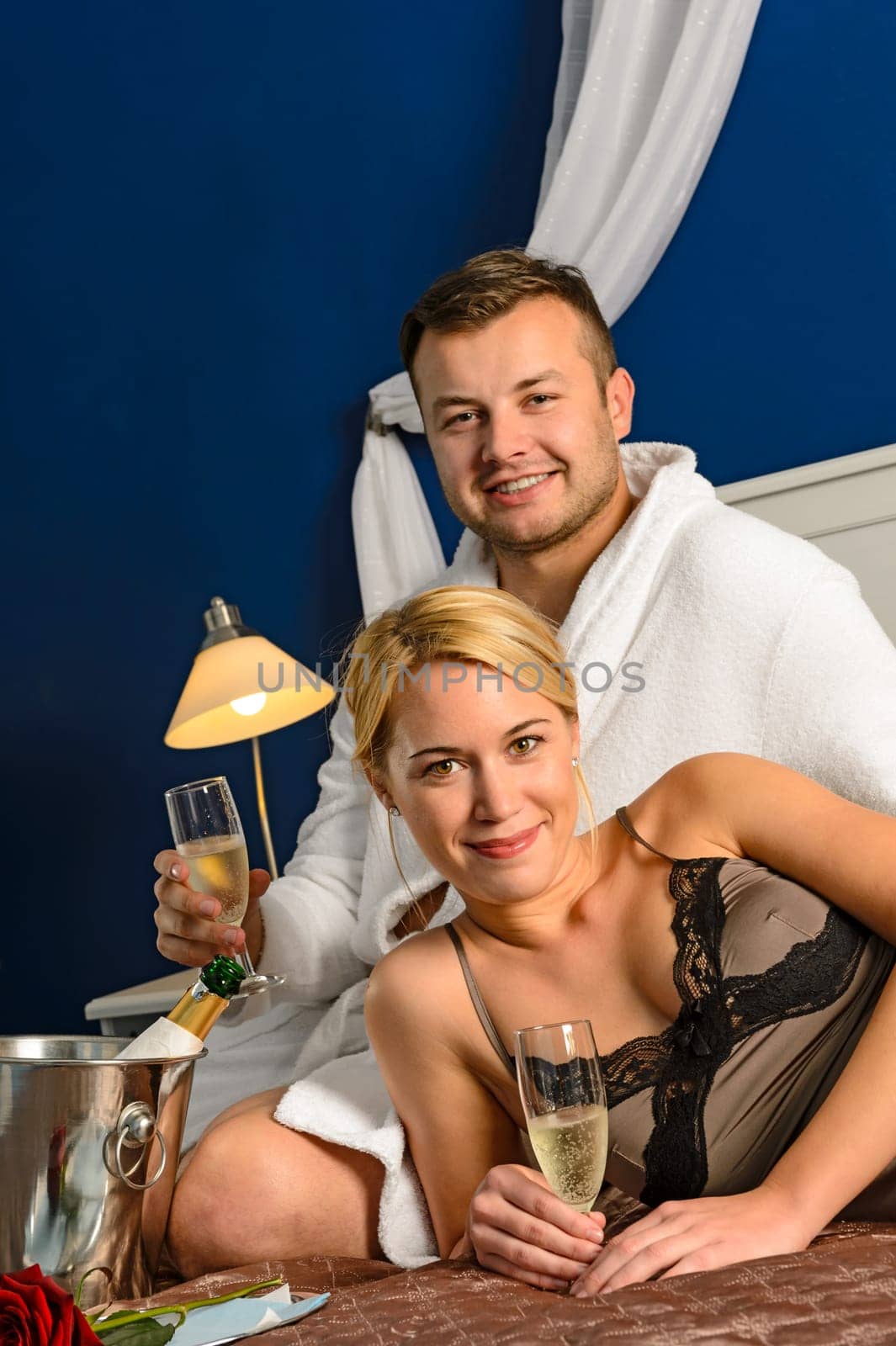 Intimate affair bed young couple drinking champagne woman nightgown