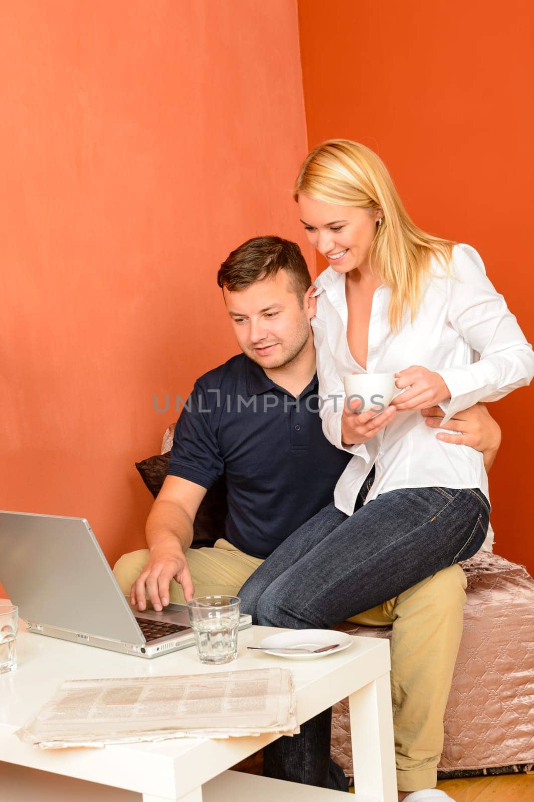 Happy couple sitting looking laptop man holding woman