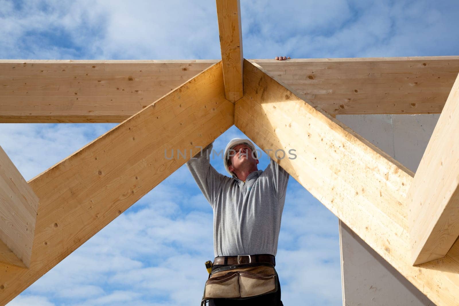 carpenter at work with wooden  roof construction