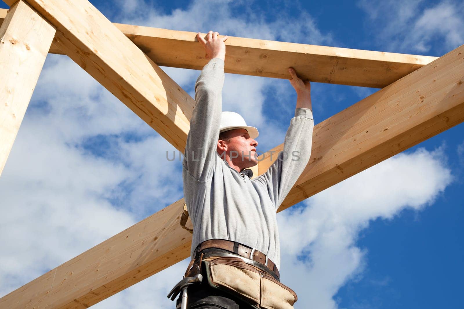 carpenter at work with wooden  roof construction