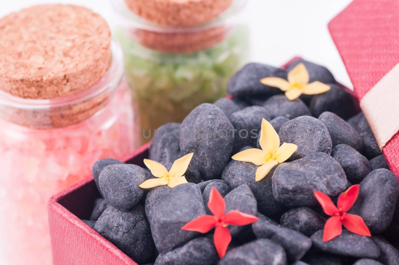 Spa concept - a gift of wellness with black zen stones and flowers