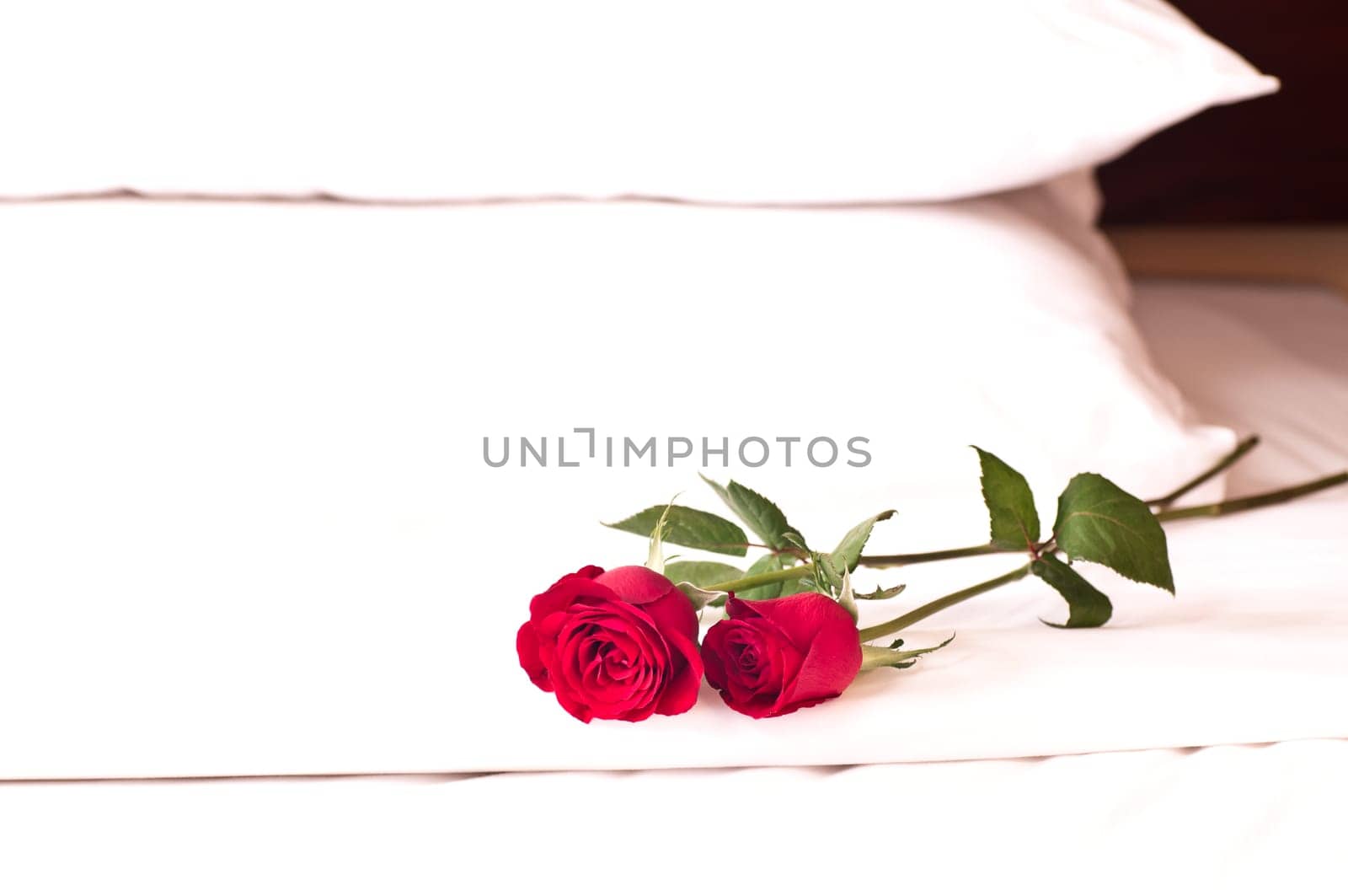 Romantic setting on a bed with red roses.