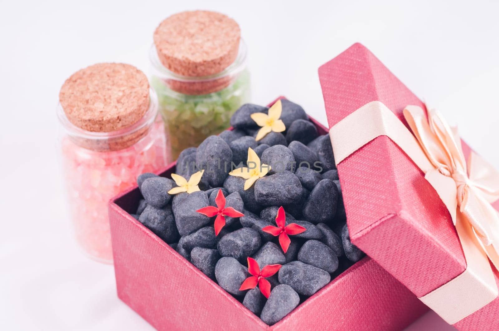 Spa concept - a gift of wellness with black zen stones and flowers