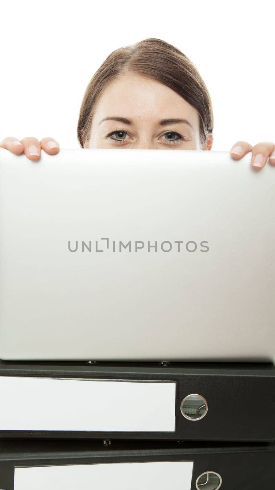 young woman hiding behind laptop and documents