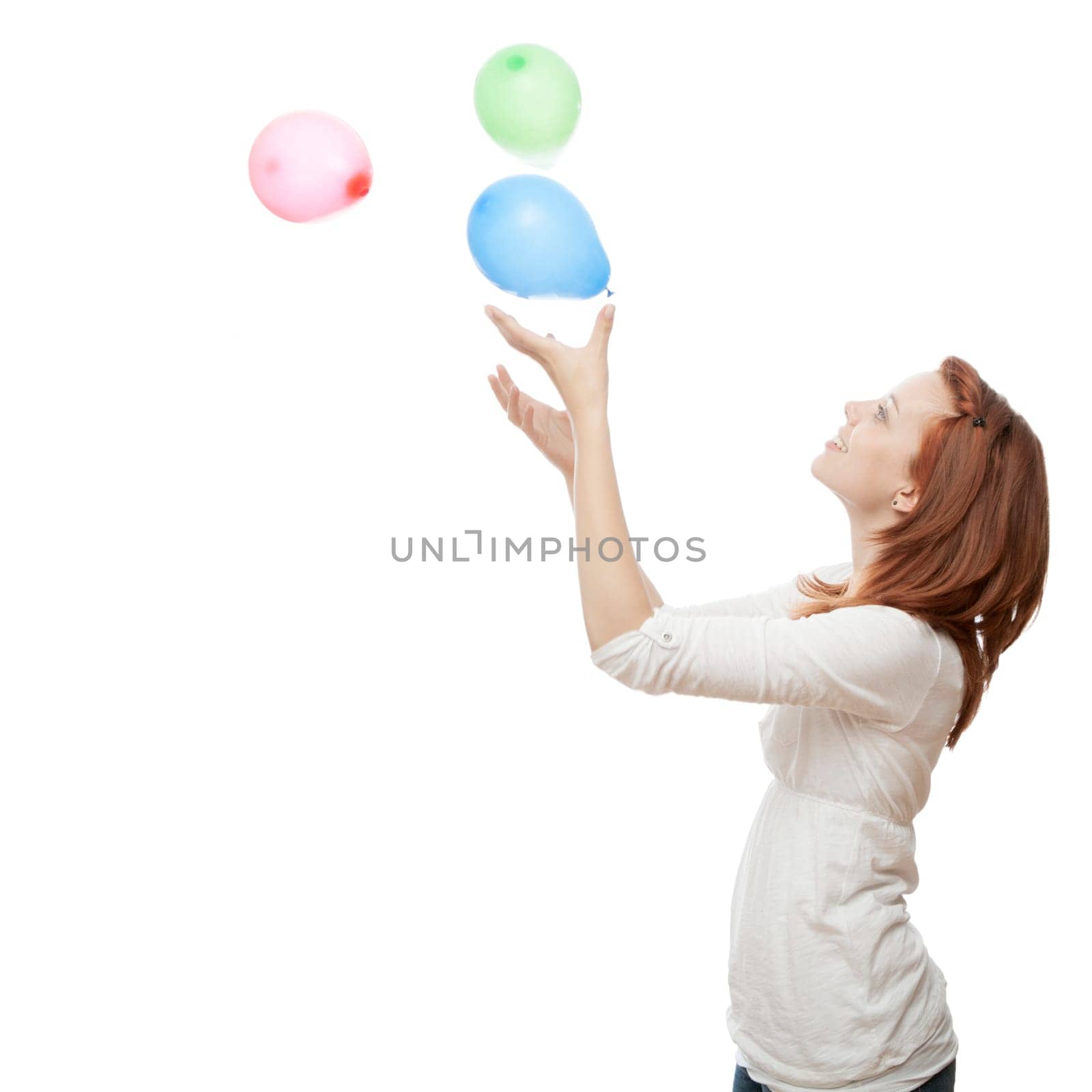 young beautiful red haired girl with ballons in front of white background