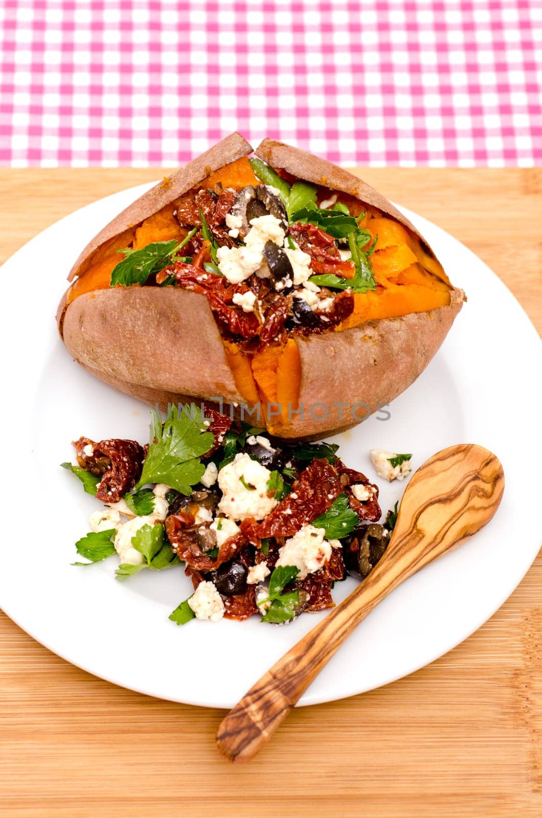Baked sweet potato with stuffing of dried tomatoes,olives and feta