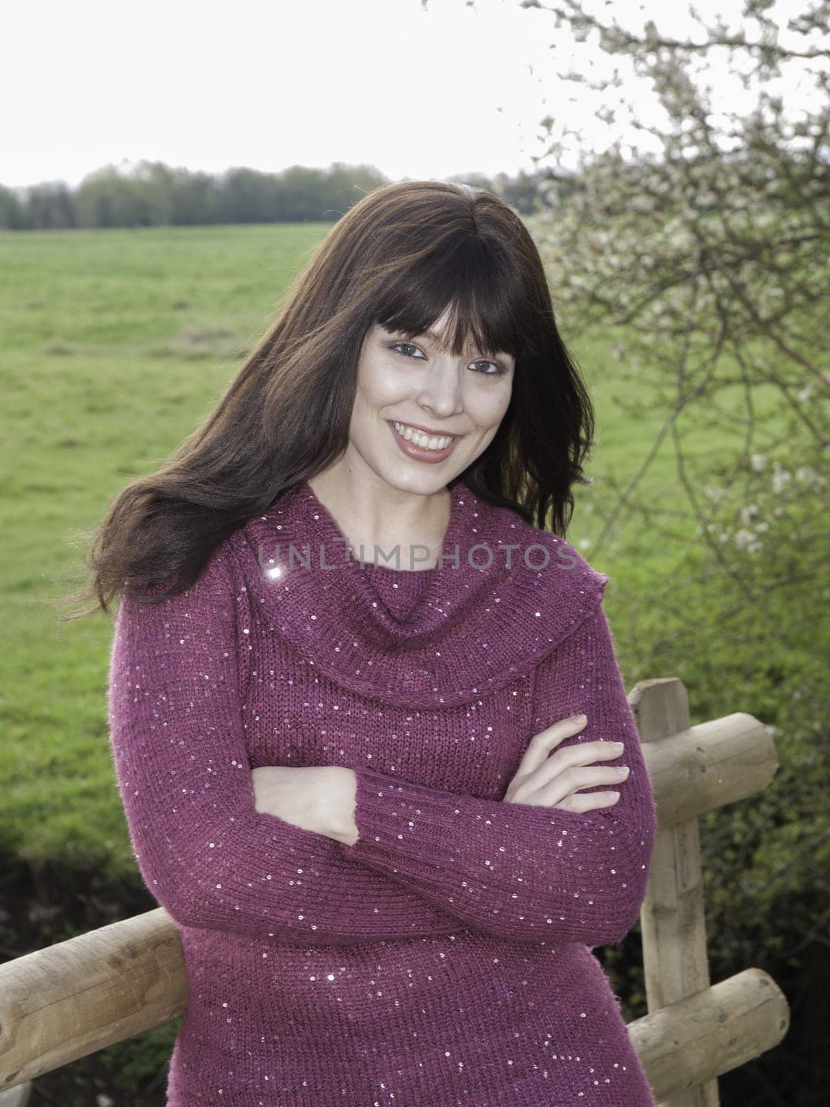 Woman standing by farmers fence in fashionable jumper