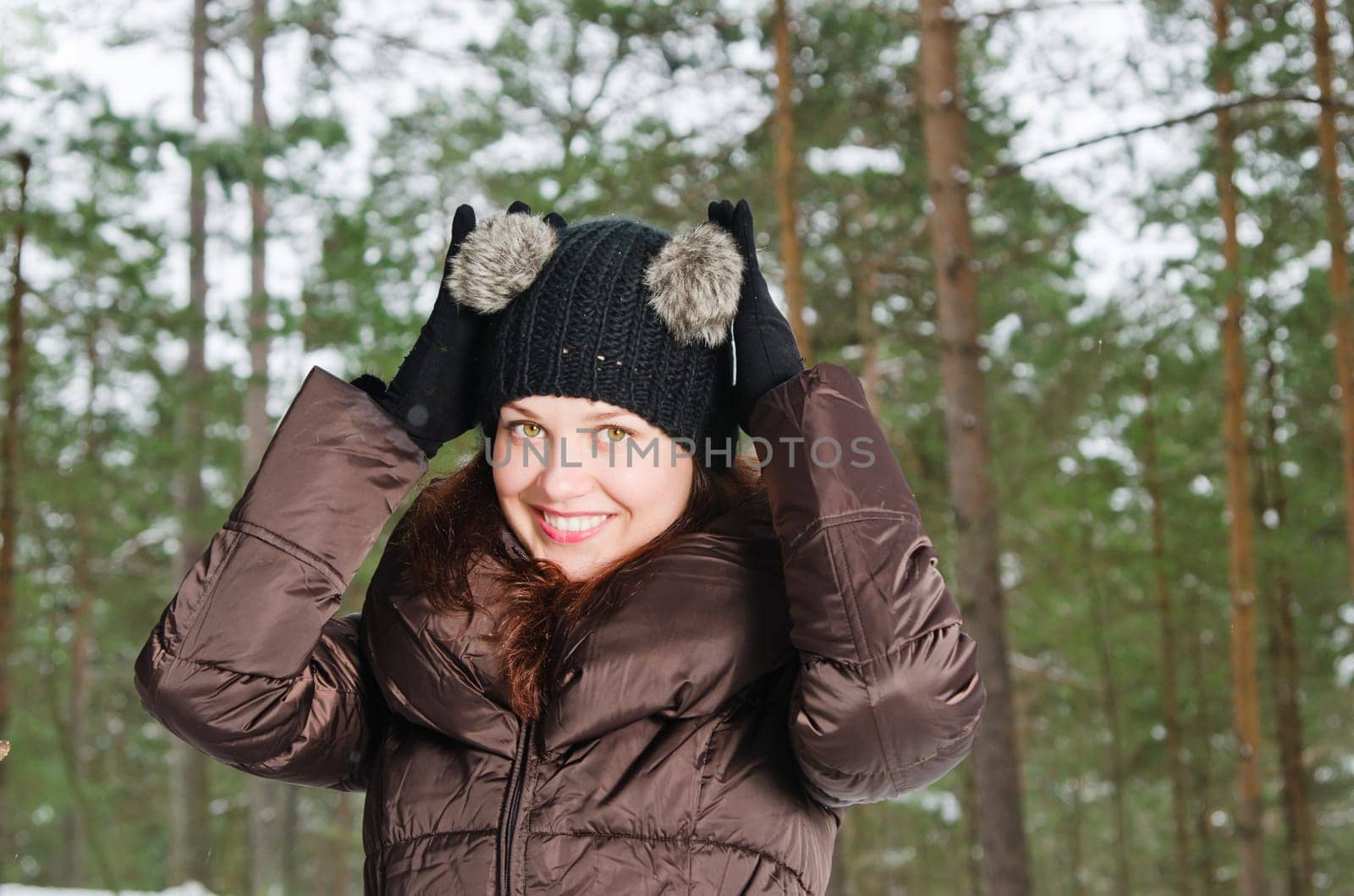 Portrait of the charming young woman in winter outdoors