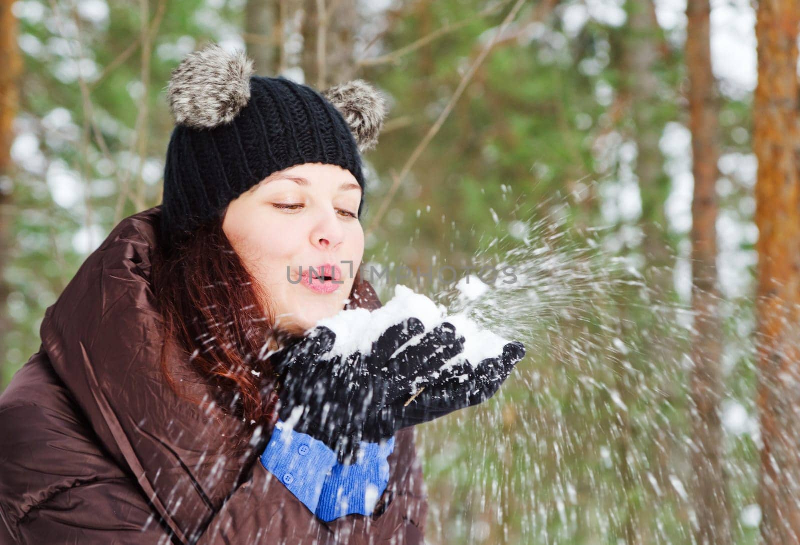 Cute young woman playing with snow  outdoors