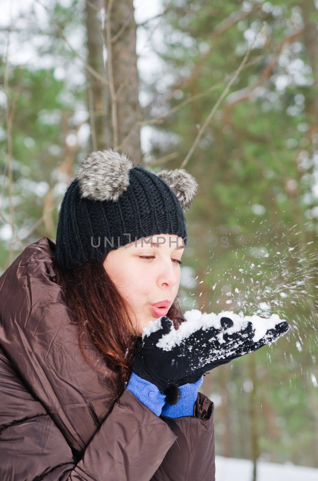 Cute young woman playing with snow  outdoors