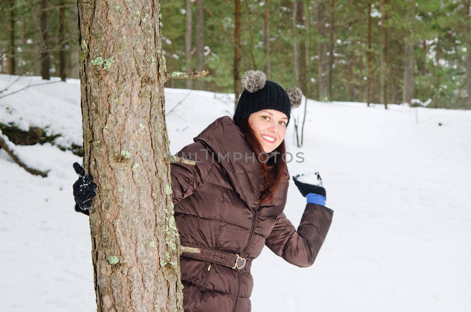 Cute young woman playing with snow  outdoors