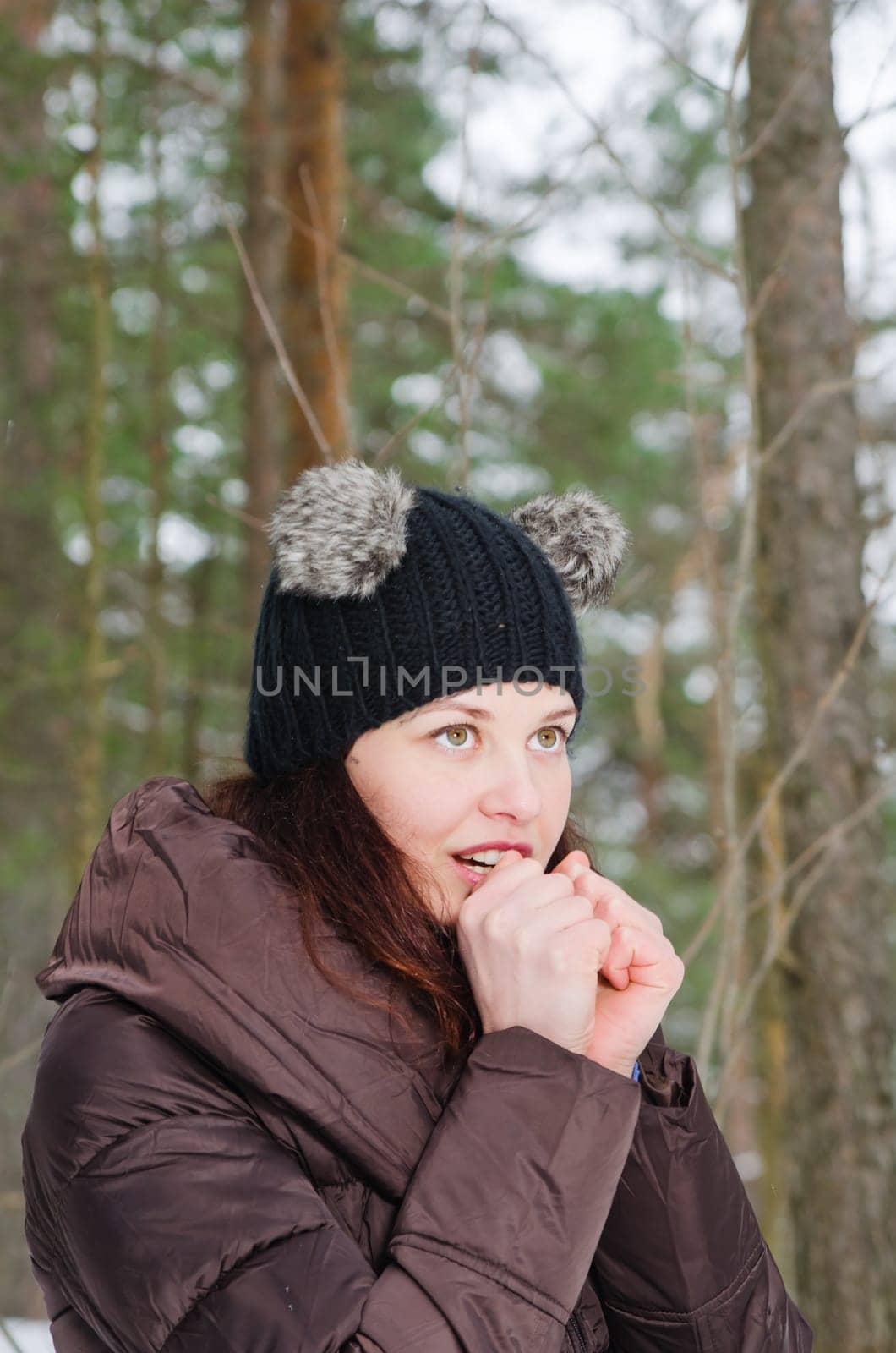 The young woman heats the frozen hands in winter park
