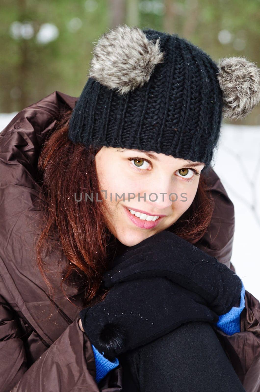 Portrait of the charming young woman in winter outdoors