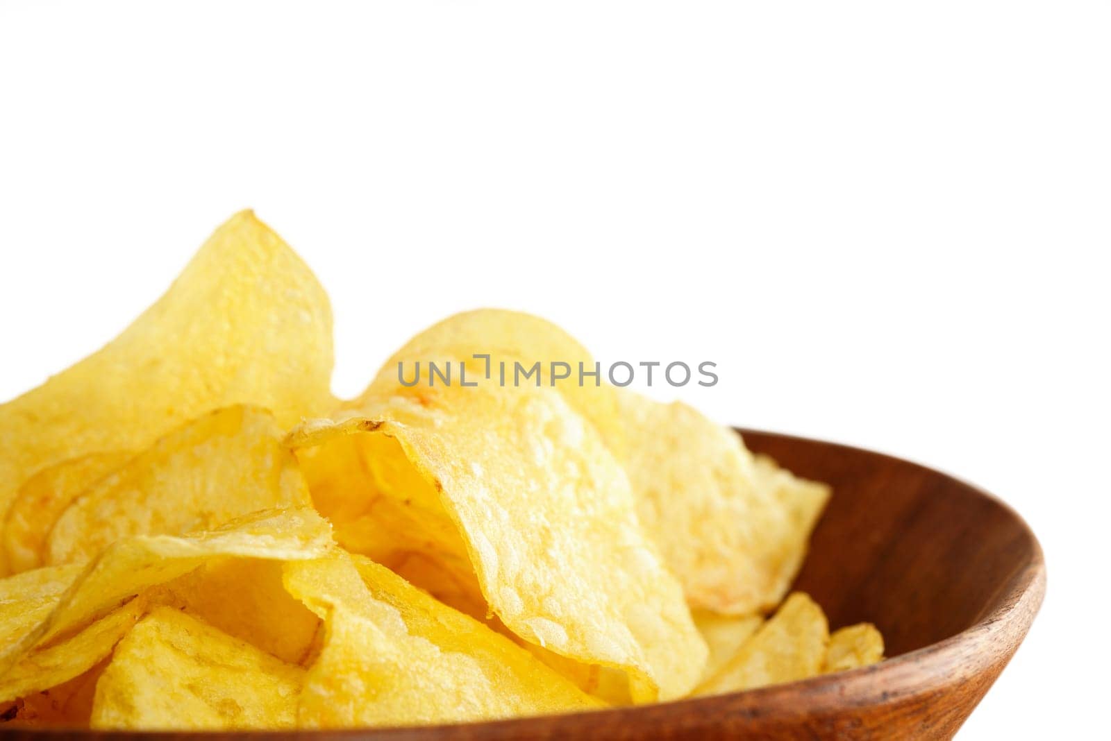 Crisps in a wooden bowl on white background