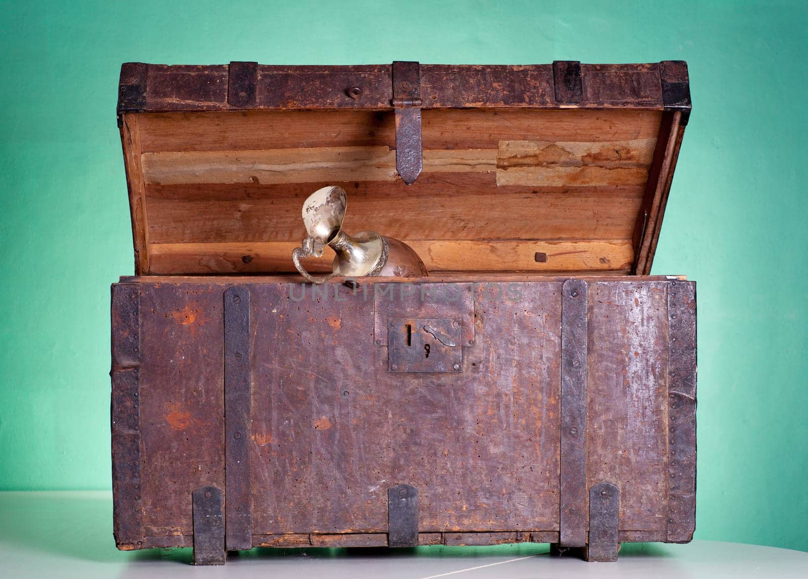Glass pitcher inside an antique wooden trunk
