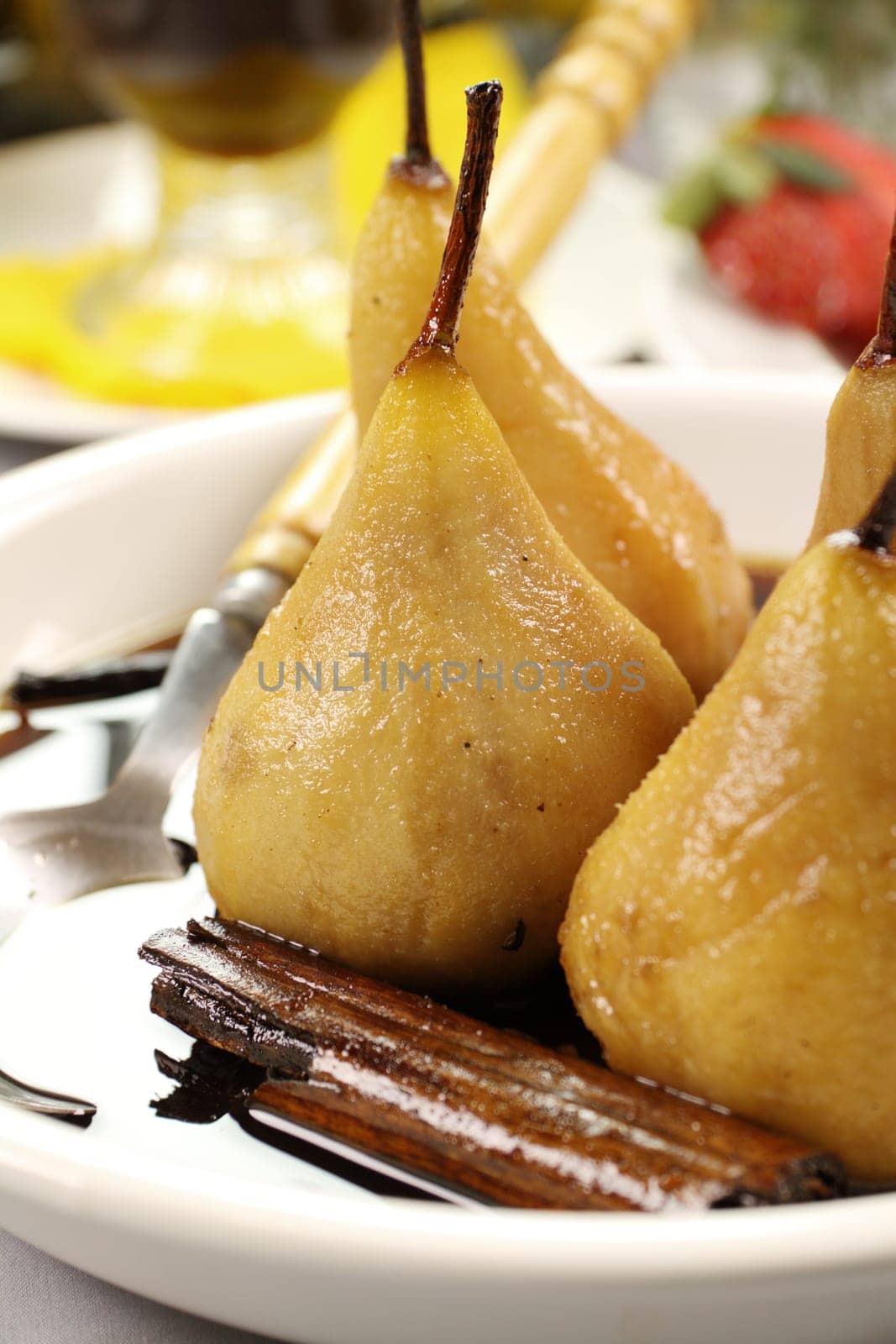 Delicious poached pears with a cinnamon stick in syrup.
