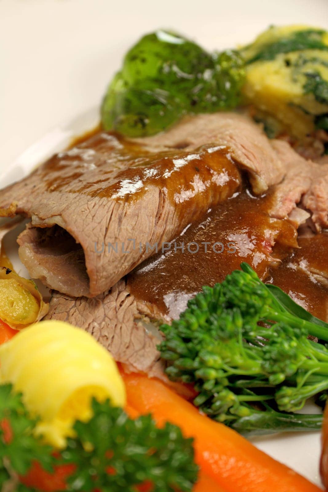 Delicious sliced roast lamb with baked vegetables and mint jelly.