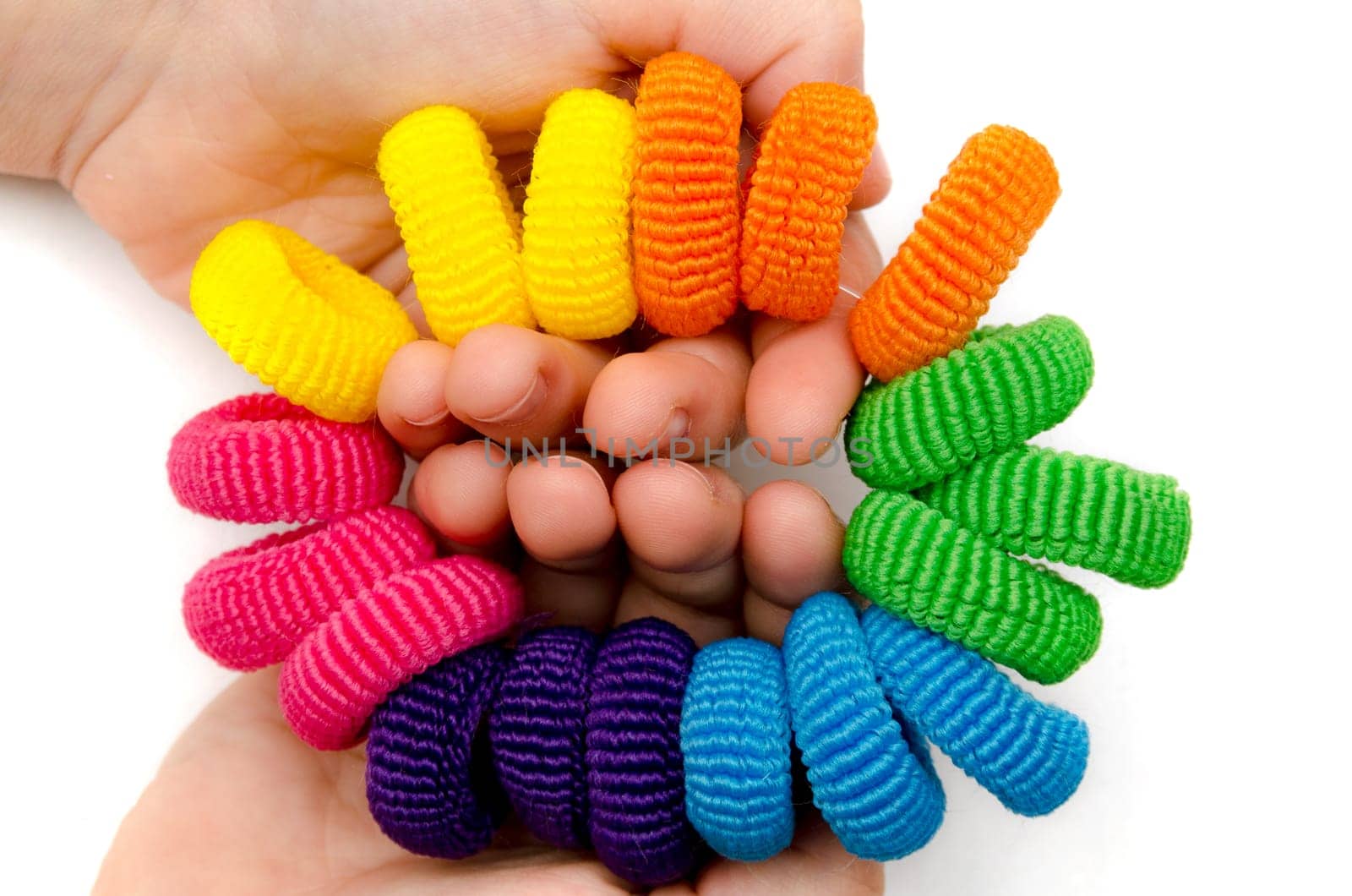 hands of a little girl with hair bands of many colors