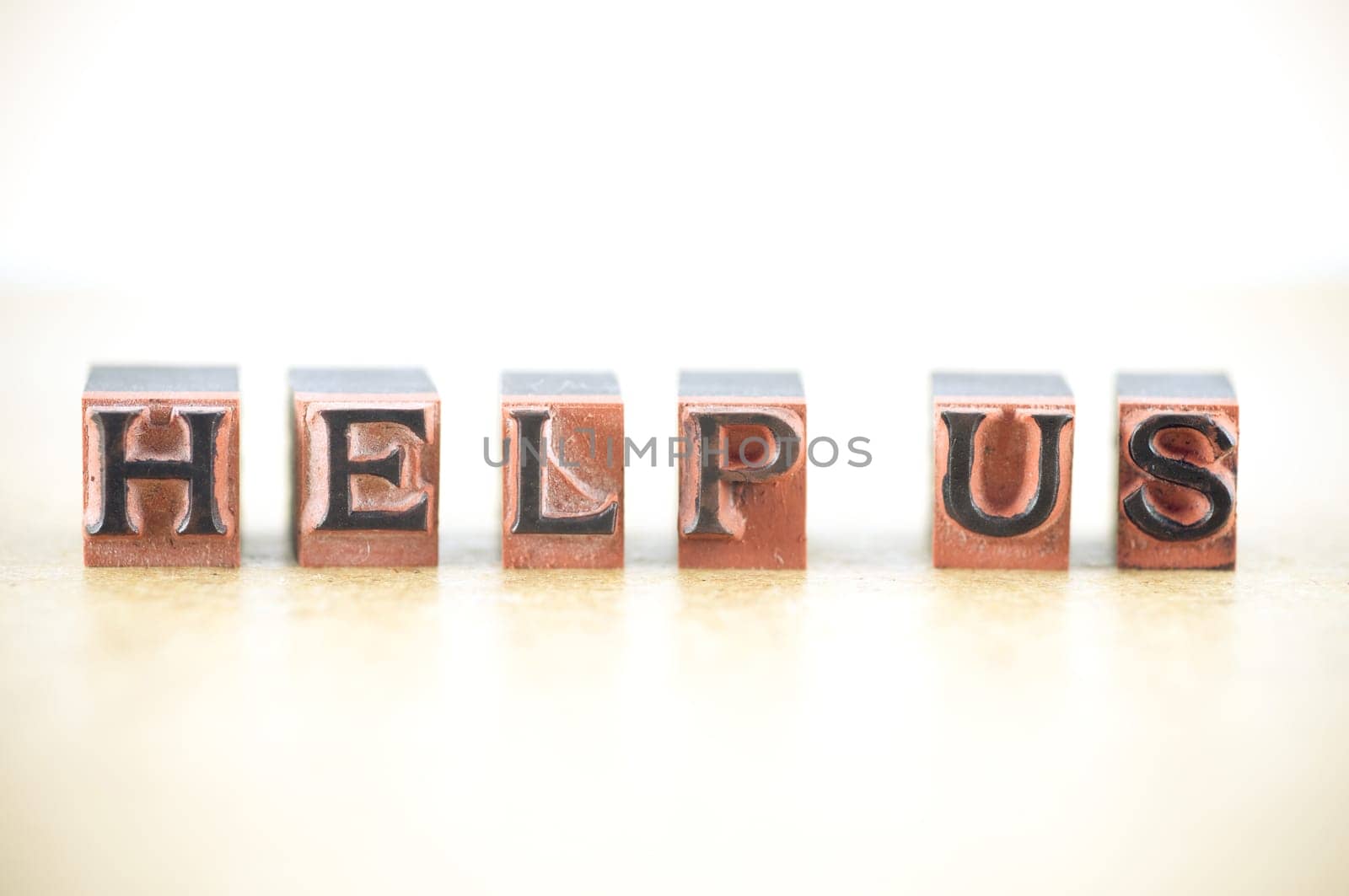 "help us"" spelled out in letterpress letters."