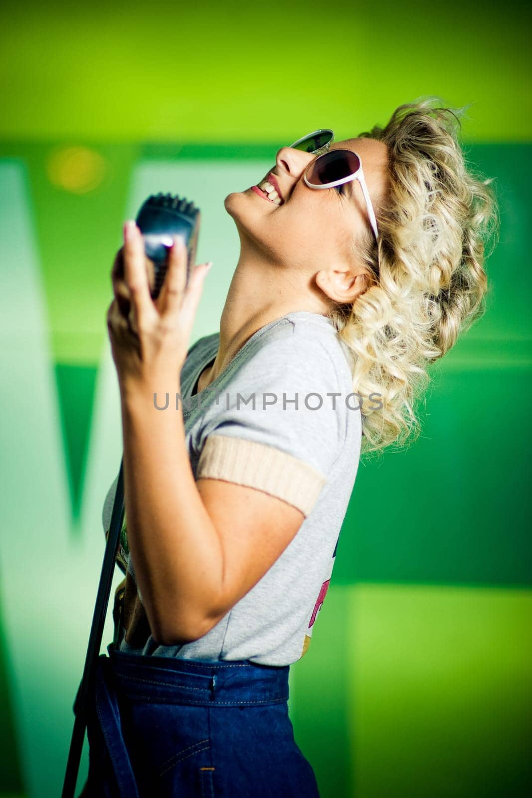 Beautiful young retro singer holding microphone