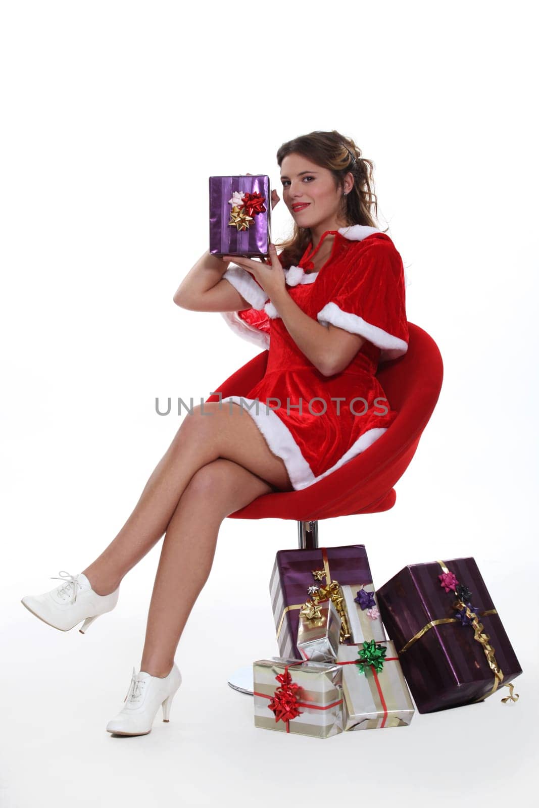 Woman dressed as Mrs. Claus holding a present