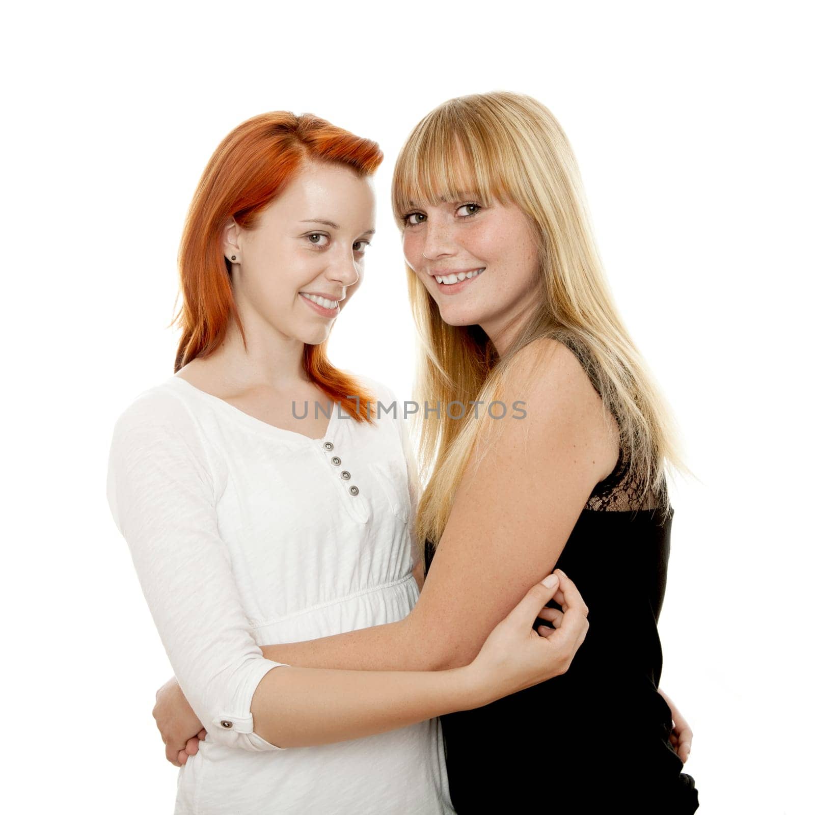 young beautiful red and blond haired girls hugs in front of white background