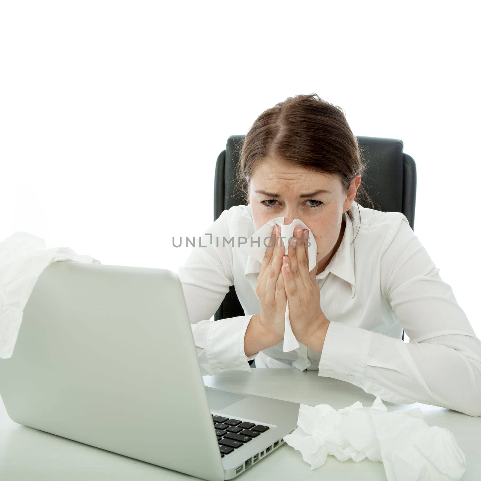 young brunette business woman is ill with hankies behind laptop