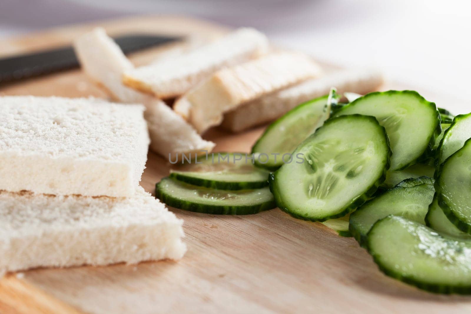 White bread with crust cut off and cucumbers to make cucumber sandwiches for afternoon tea