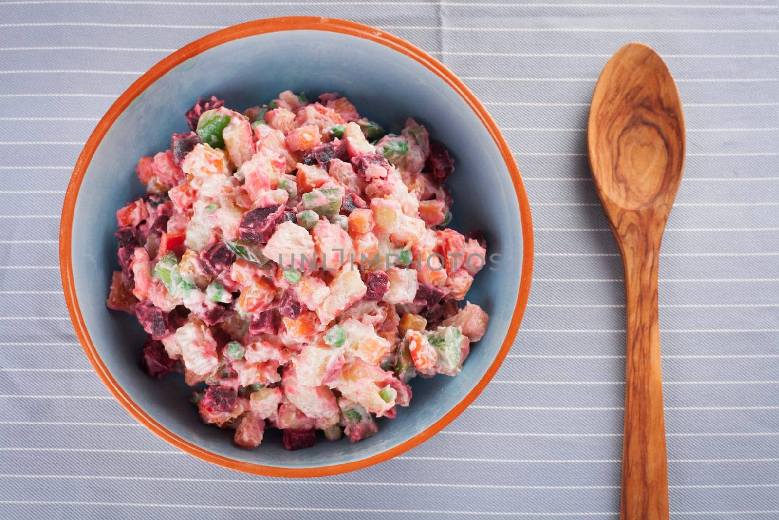 Haitian potato salad, salad pomdete,    with wooden serving spoon.