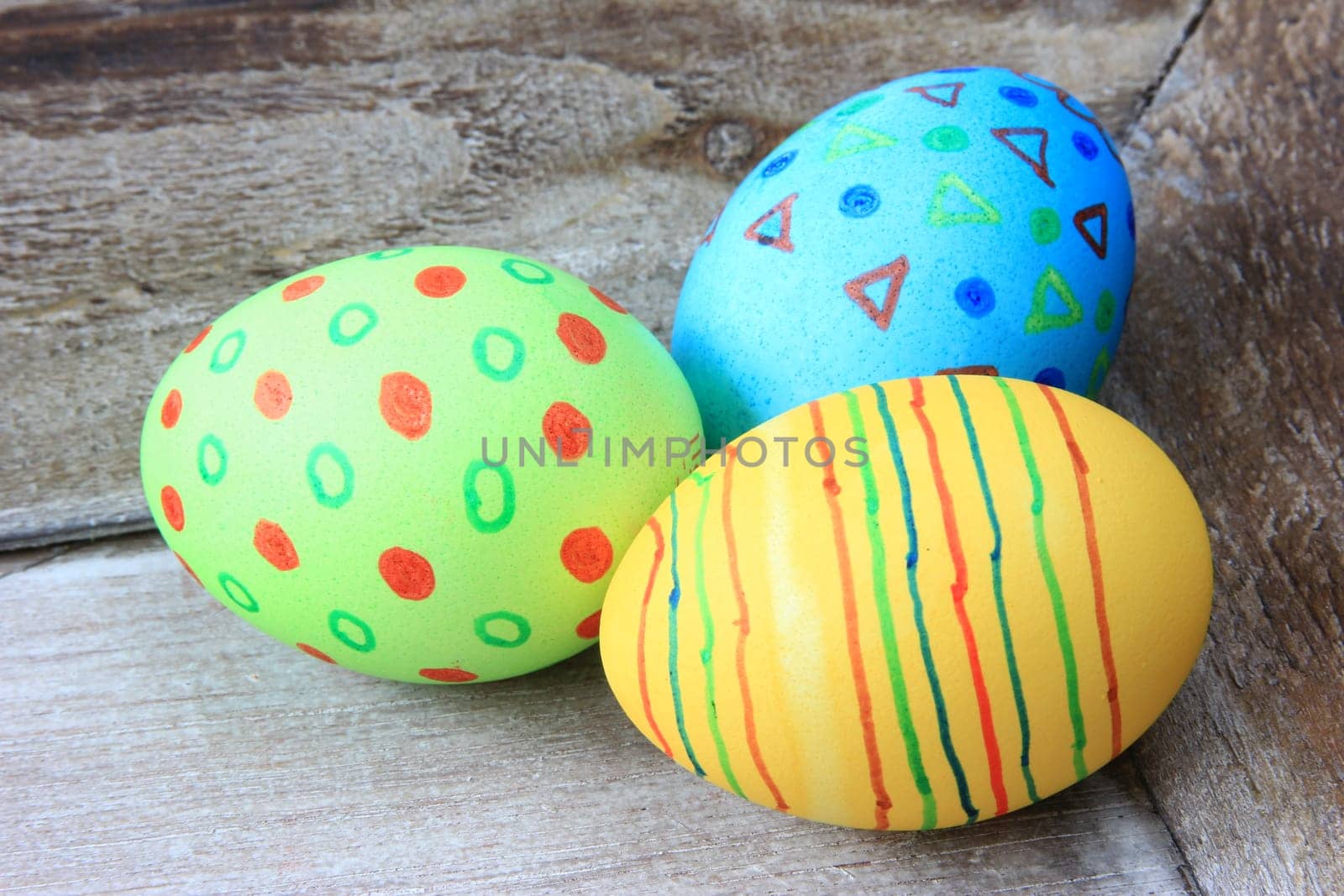 brightly colored Easter eggs on old,gray wooden board