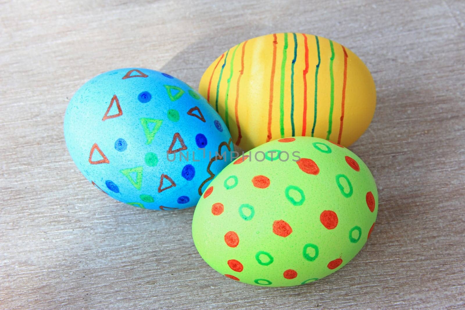 brightly colored Easter eggs on old,gray wooden board
