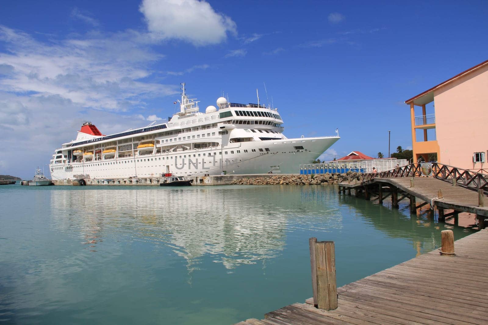 Cruise ship docked in St. John’s Harbour in Antigua Barbuda with copy space in the sky and on the water.
