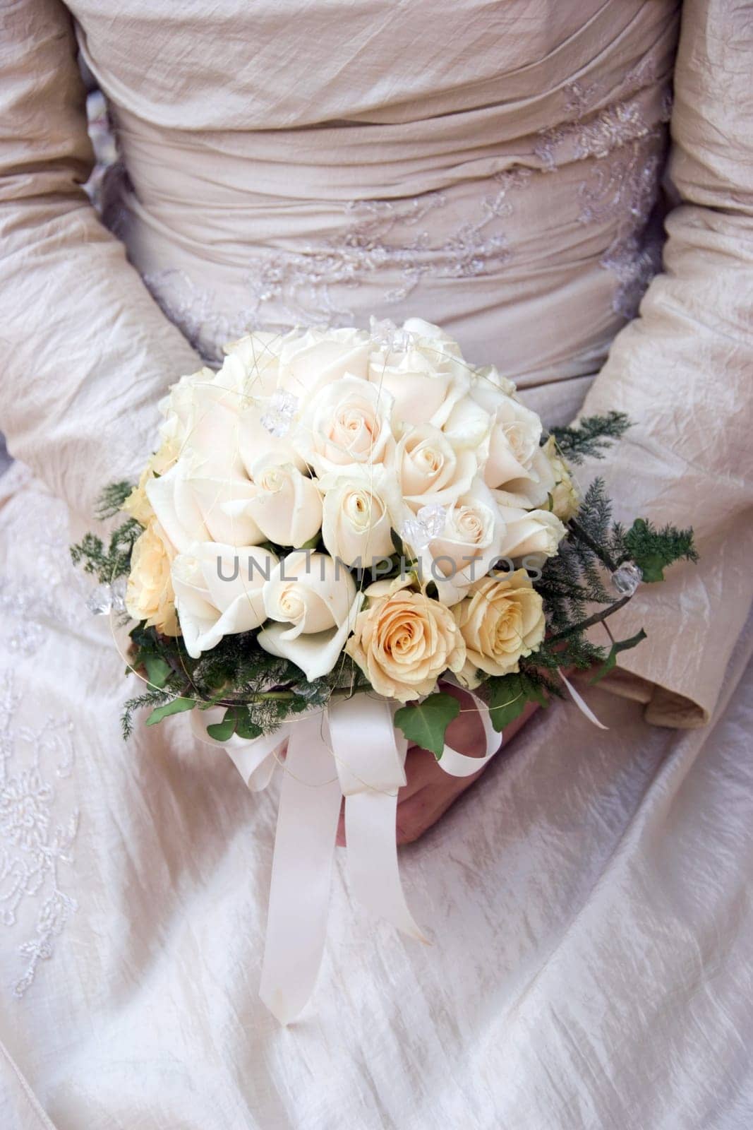 Bride is holding wedding bouquet made from roses