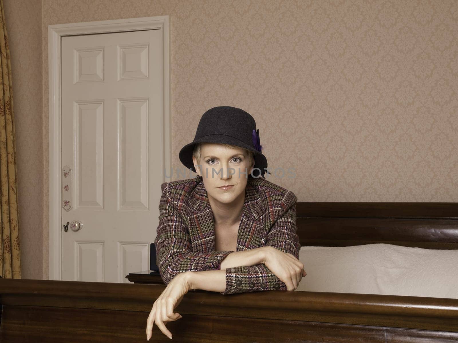 Woman wearing lingerie with a tweed jacket and hat