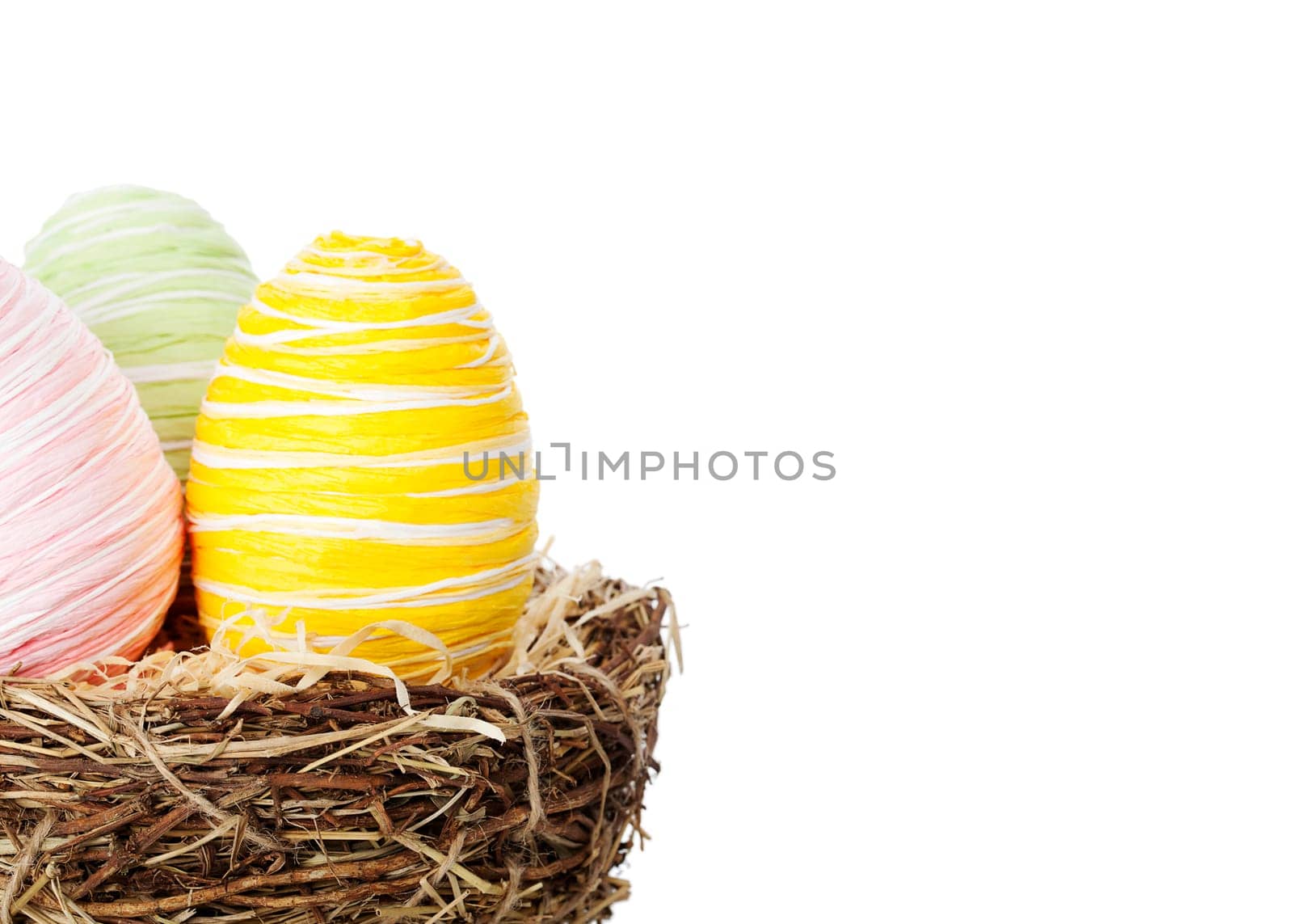 Colourful Easter eggs in a nest isolated over white background, offset from centre to allow space for your text