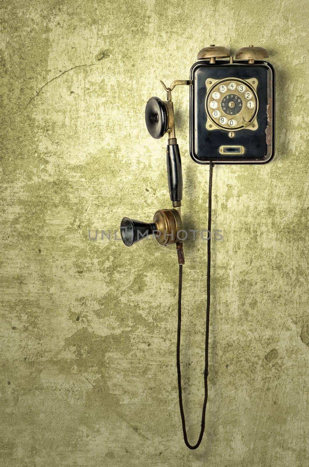 Antique telephone on a yellow weathered wall