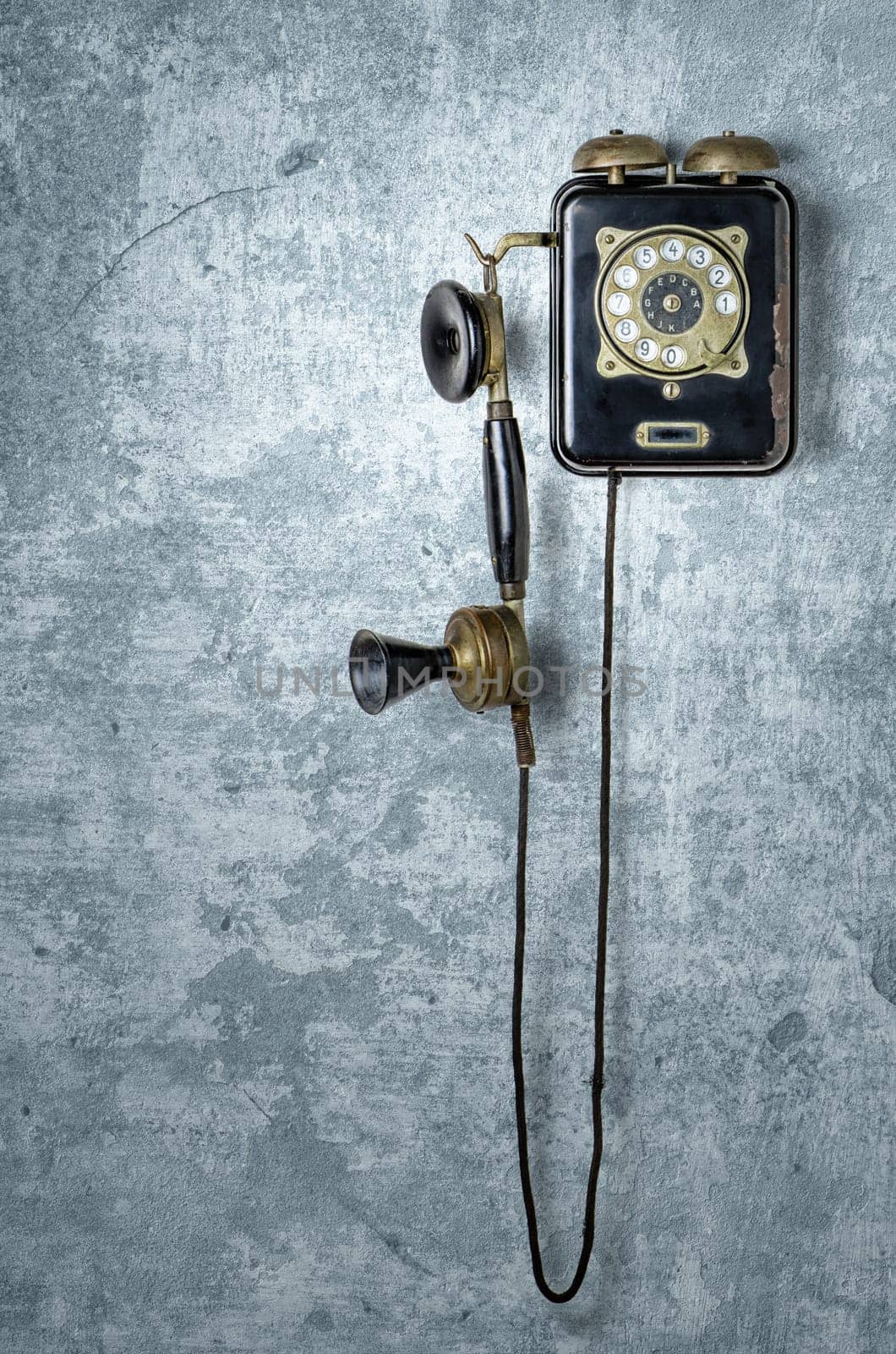 Antique telephone on a blue weathered wall