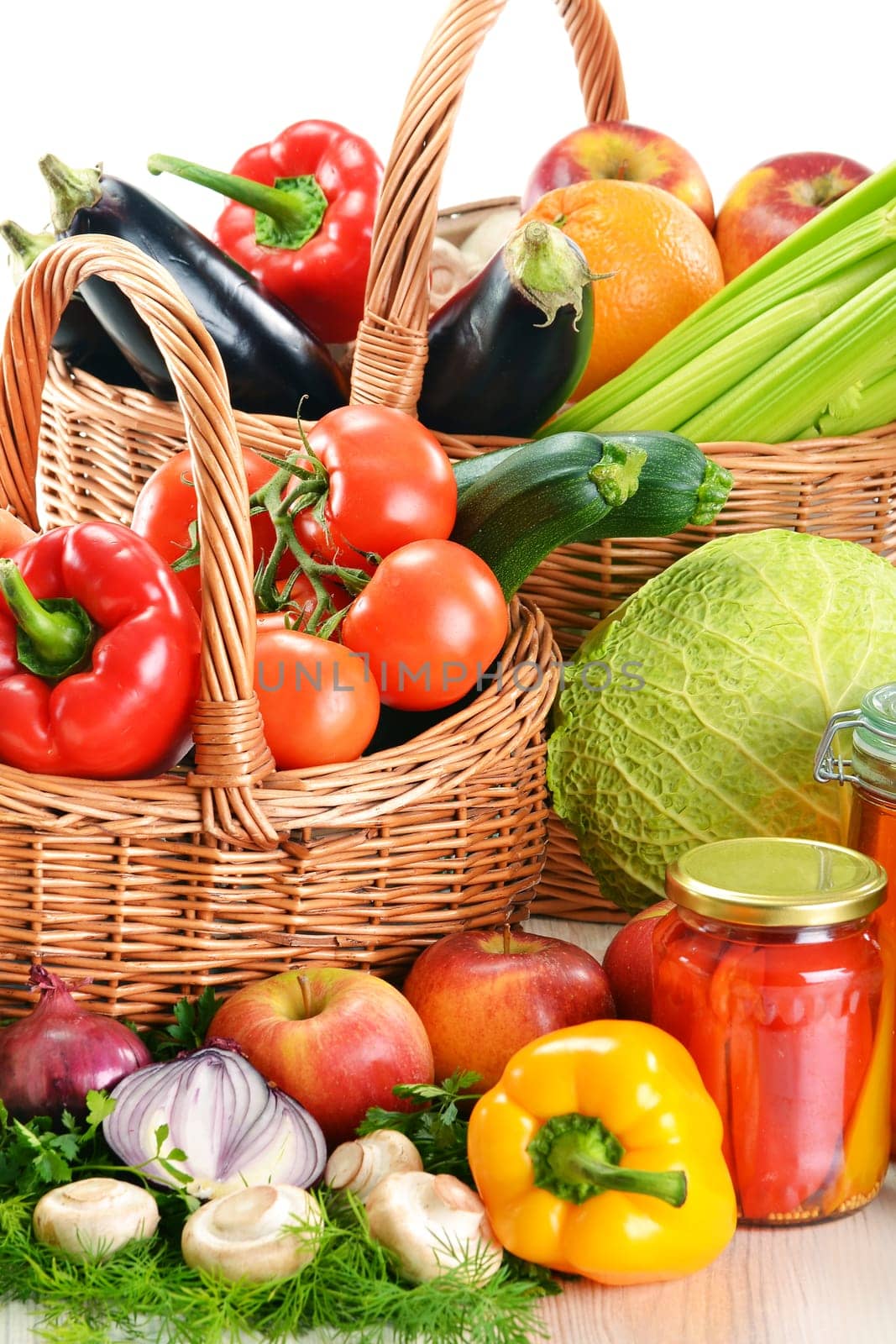 Composition with wicker basket and grocery isolated on white